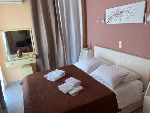 a bedroom with a bed with two towels on it at Despoina Apartments in Edipsos