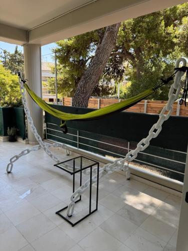 a hammock on the porch of a house at Oasis 3 minutes from the beach in Vari