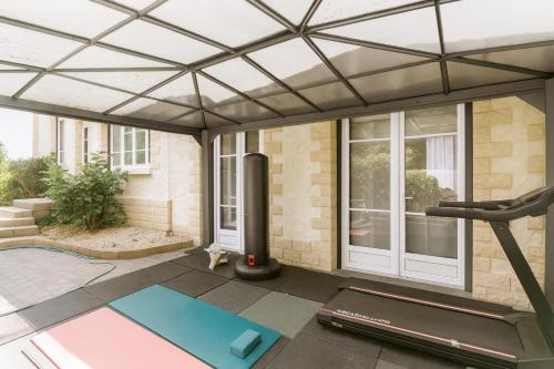 a fitness room with a gym and a house at Villa Maxonale pour séjour famille uniquement in Villemoisson-sur-Orge