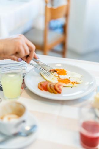 a person holding a knife and fork and a plate of food at HOTEL CONTI in San Mauro a Mare