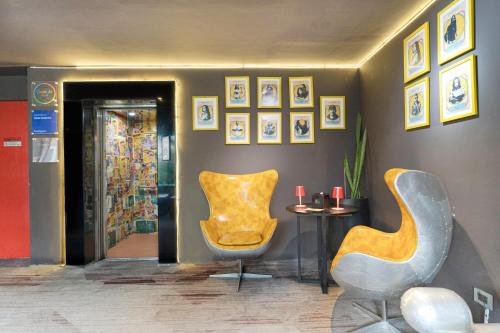 a room with two chairs and a table and pictures at Gaas BaasCo in Kathmandu
