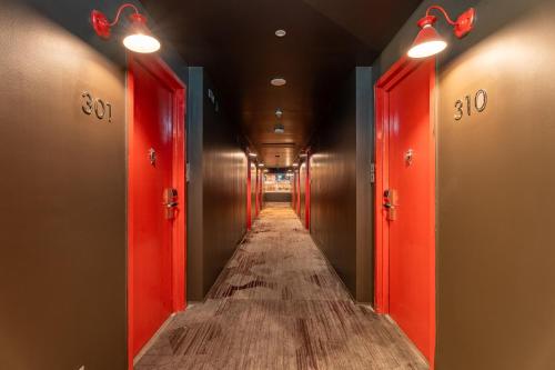 a hallway with red doors and a long aisle at Gaas BaasCo in Kathmandu