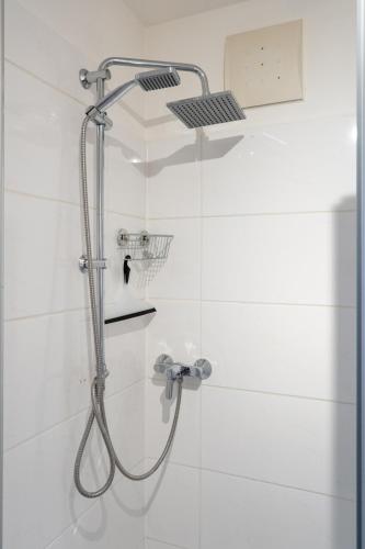 a shower with a shower head in a bathroom at FarawayHomes Studios Klosterneuburg in Klosterneuburg