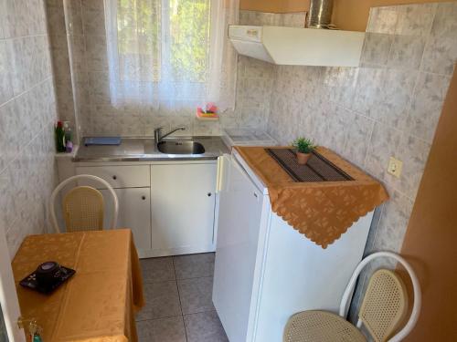 a small kitchen with a sink and a table at Despoina Apartments in Edipsos