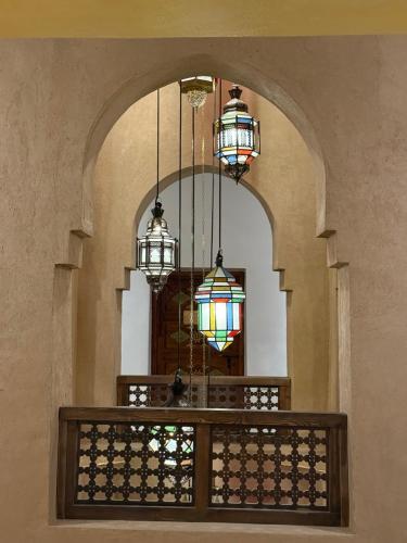 a hallway with three chandeliers in a building at Kasbah Hnini in Igdourane
