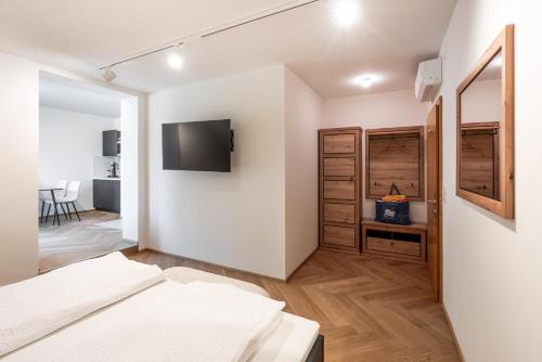 イェナースドルフにあるSISTERS Haus Hotel Garniのベッドと壁掛けテレビのある寝室