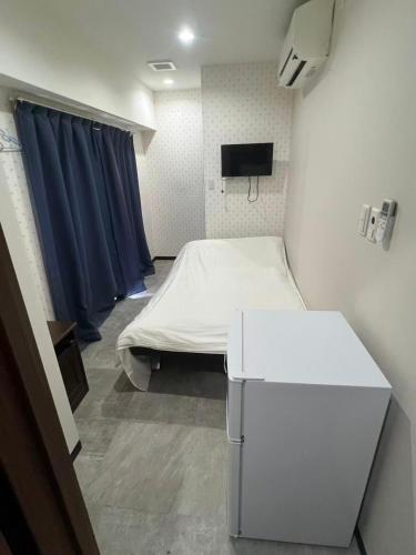 a hospital room with a bed and a tv at 依茶宿 in Matsudo