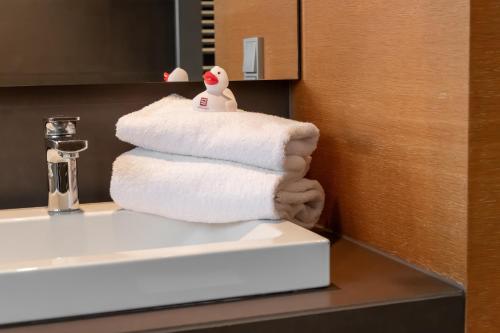 a stack of towels sitting on top of a bathroom sink at Schlossgut Gross Schwansee in Groß Schwansee