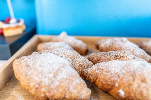 a tray of donuts with powdered sugar on it at HOTEL CONTI in San Mauro a Mare