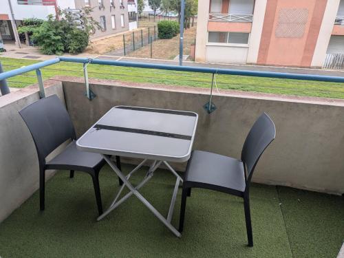 a table and two chairs on a balcony at Appart T1bis 31m2 Blagnac proche Tram in Blagnac