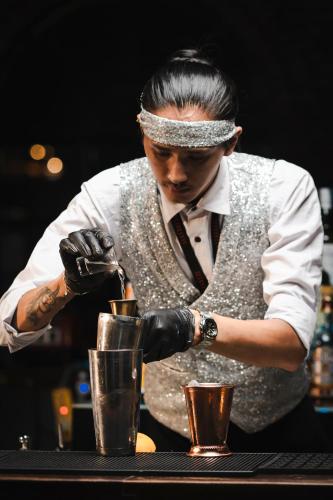 a man is making a drink at a bar at Gaas BaasCo in Kathmandu