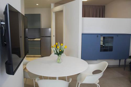 a white table with a vase of flowers on it in a kitchen at Appartamento Ralf in centro in Castelsardo