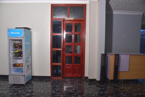 a red door is next to a refrigerator at Kanamba invent hotel in Kasese
