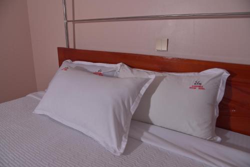 two white pillows sitting on top of a bed at Kanamba invent hotel in Kasese