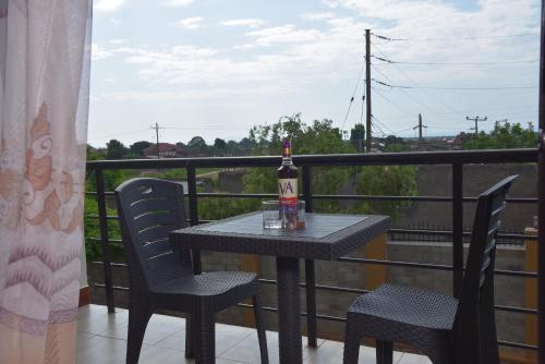 a bottle of alcohol sitting on a table on a balcony at Kanamba invent hotel in Kasese