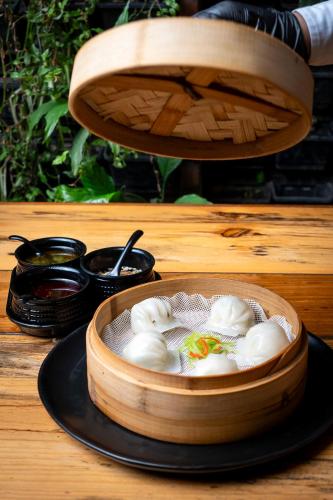a wooden bowl filled with dumplings on a table at Gaas BaasCo in Kathmandu