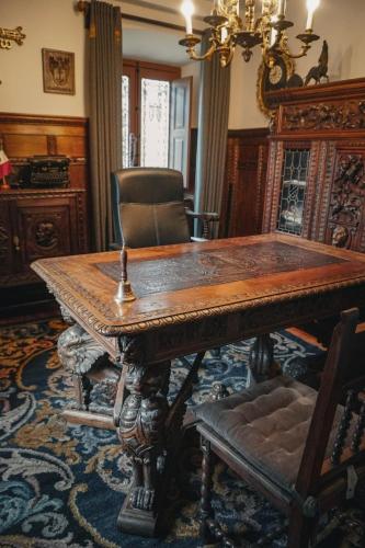 a dining room with a wooden table and a chair at Casa Puebla Historia y Elegancia in Cangas de Onís