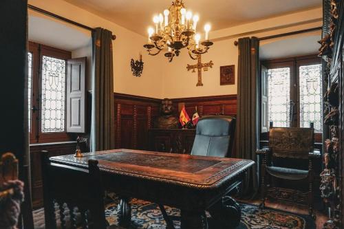 a dining room with a table and a chandelier at Casa Puebla Historia y Elegancia in Cangas de Onís