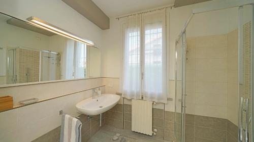 un bagno con lavandino e doccia in vetro di Garda Prestige Retreat a Moniga