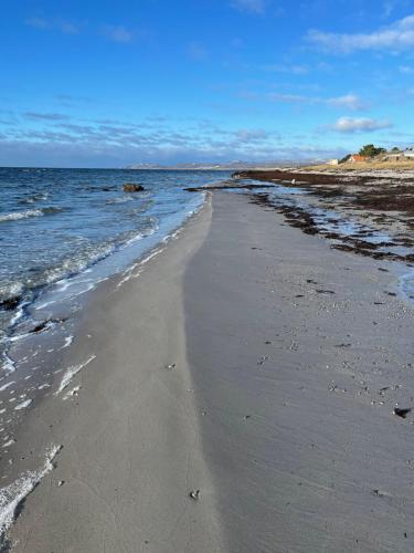 a beach with the ocean and the shoreline at Havsnära studio in Höganäs