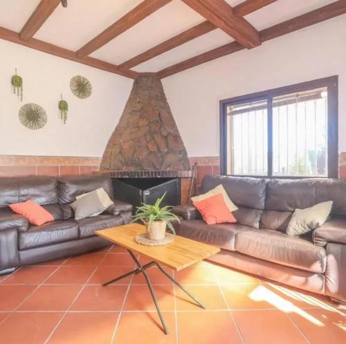 a living room with a couch and a fireplace at Spacious Villa in Guillena with Garden and Private Pool in Guillena