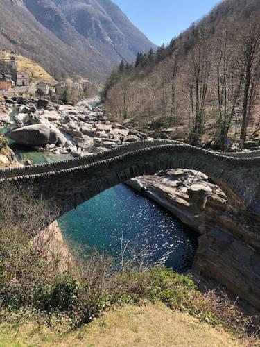a stone bridge over a river in a mountain at Casa Aviva in Muralto