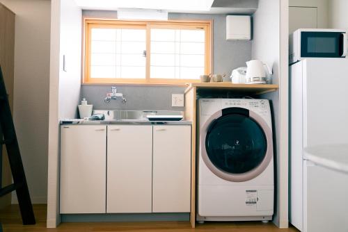 a laundry room with a washing machine and a sink at Yokohama NOIE 横浜ノイエ in Yokohama