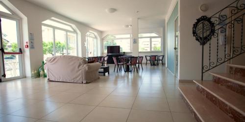 a living room with a white chair and a table at HOTEL CONTI in San Mauro a Mare