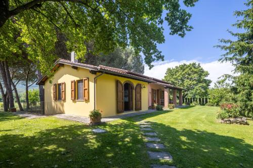 a small yellow house with a grass yard at Campo Grande by VacaVilla in Santa Cristina