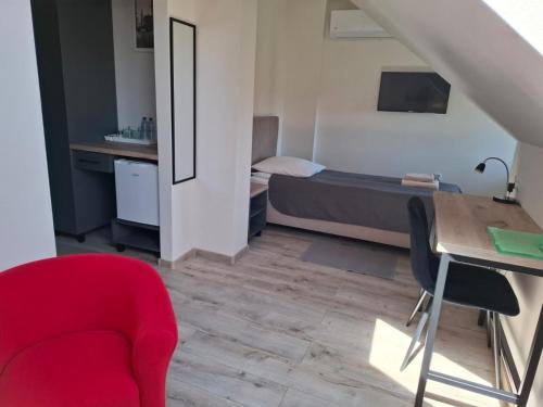 a room with a bed and a desk and a red chair at Restauracja -Zajazd trzech braci in Cieszyn