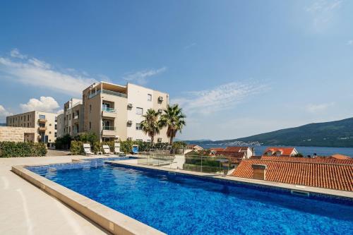 - une piscine avec vue sur un bâtiment dans l'établissement New luxes white apartments, à Baošići