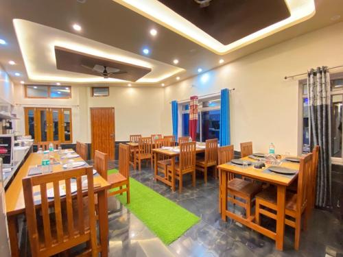 a dining room with wooden tables and chairs at Geetanjali Palace Hotel & Restaurant in Rudraprayāg