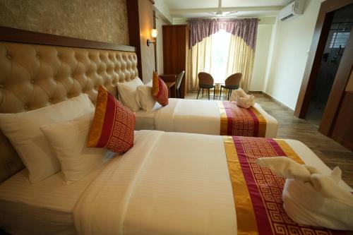 a hotel room with two beds and a window at Captains Crown Hotels & Resorts in Kushālnagar