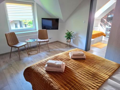 a bedroom with a bed with two towels on it at Restauracja -Zajazd trzech braci in Cieszyn