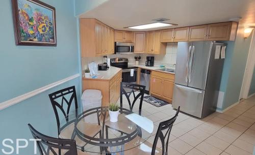 a kitchen with a table and chairs and a refrigerator at Aquarius 408 in South Padre Island