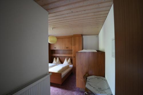 a small room with two beds and a chair at Boarhof in San Giacomo Val di Vizze