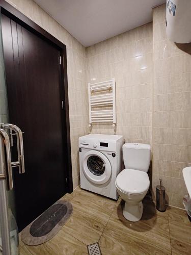 a bathroom with a toilet and a washing machine at Tribu in Bakuriani