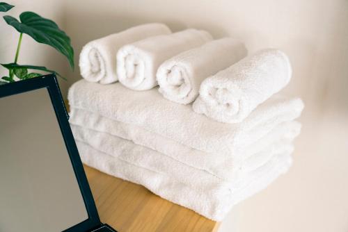 a stack of towels on a table next to a mirror at Yokohama NOIE 横浜ノイエ in Yokohama
