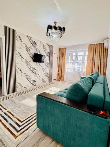 a living room with a green couch and a marble wall at Толебаева Центр Талдыкорган in Taldykorgan