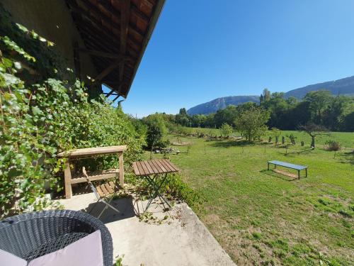 un tavolo da picnic e una panchina in un campo di Séjour paisible près de Genève a Neydens
