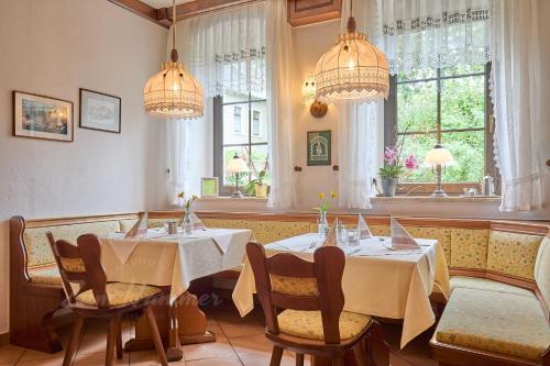 a restaurant with two tables and chairs and windows at Landhotel Zum Hammer in Tannenberg