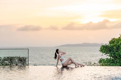 a woman in a bikini sitting in the water at Royal Cliff Grand Hotel Pattaya in Pattaya South