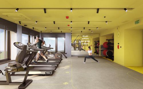 a gym with two people exercising on treadmills at Hampton By Hilton Wroclaw Airport in Wrocław