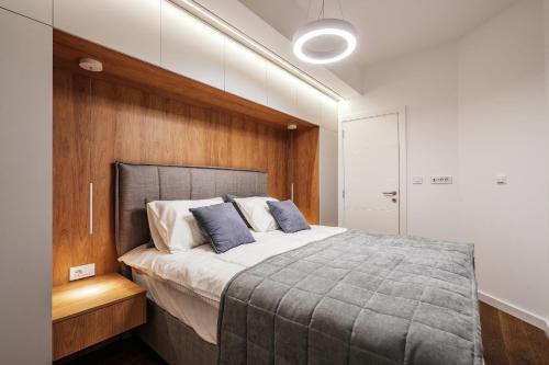 une chambre avec un grand lit avec un mur en bois dans l'établissement New luxes white apartments, à Baošići