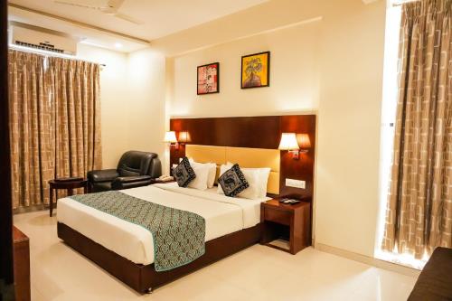 a hotel room with a bed and a chair at Hotel Sai Jashan Shirdi - Where blessings & comfort meet in Shirdi