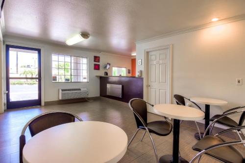 a room with two tables and chairs and a kitchen at Motel 6-Menifee, CA in Menifee