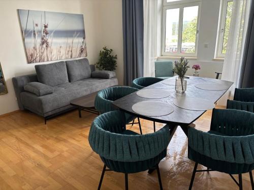 a living room with a table and chairs and a couch at FarawayHomes Studios Klosterneuburg in Klosterneuburg