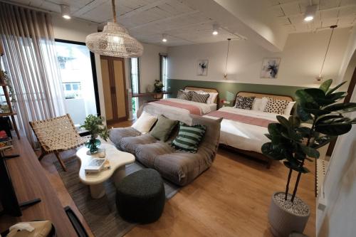 a living room with two beds and a couch at The Shantipan Jasmine - Cozy City Retreat 400m from BTS Station in Bangkok