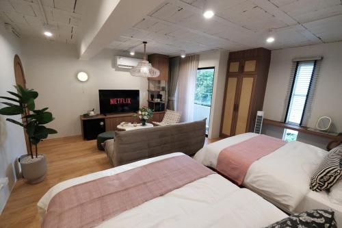 バンコクにあるThe Shantipan Jasmine - Cozy City Retreat 400m from BTS Stationのベッド2台とソファのあるリビングルーム