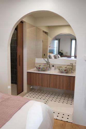 a bathroom with a sink and a mirror at The Shantipan Jasmine - Cozy City Retreat 400m from BTS Station in Bangkok
